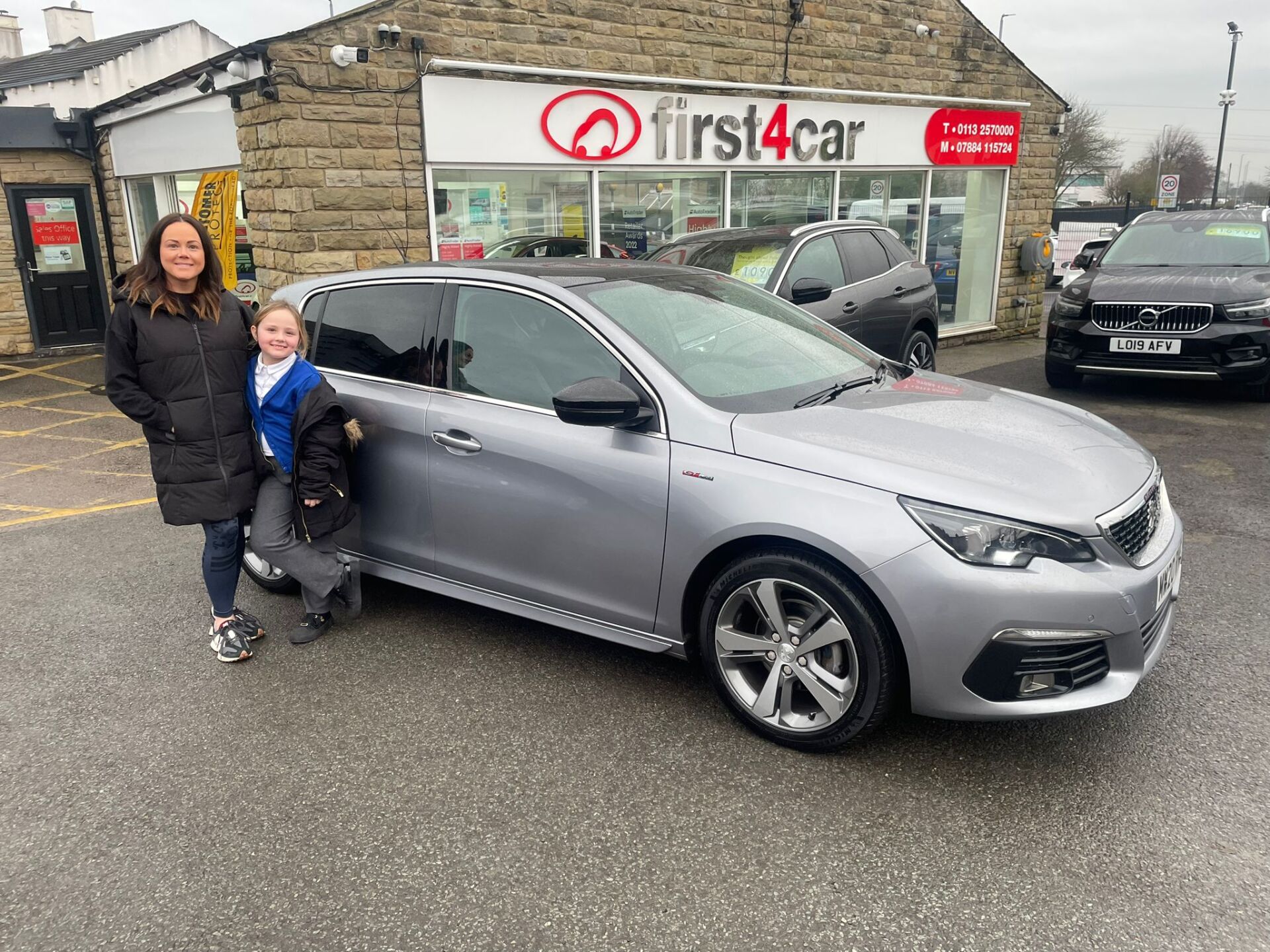 Sarah and her daughter from Leeds collecting their new family car a Peugeot 308.