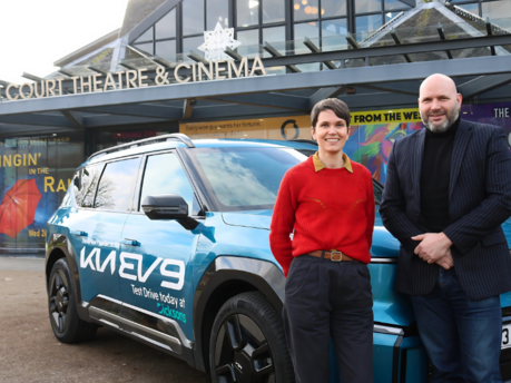 Image of Fraser Bryce and Aelish O'Rourke outside Eden Court Theatre & Cinema with a Kia EV9 beside them.