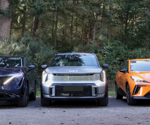 Image of three EVs from Nissan, Kia and MG lined up in a forest.