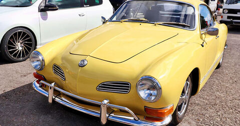 Yellow Volkswagen Karmann Ghia classic car displayed at Simply VW 2025, Beaulieu Motor Museum.