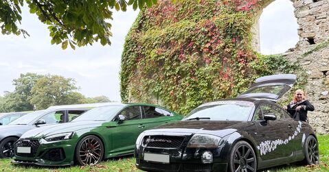 Green Audi RS and black Audi TT parked beside historic stone ruins at Beaulieu Motor Museum during Simply Audi 2025.
