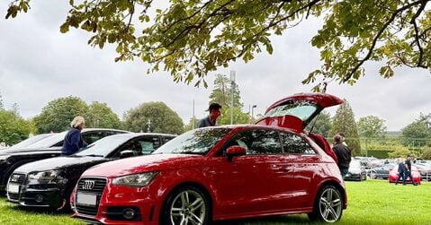 Red Audi hatchback on display with owners and visitors at Simply Audi 2025 in Beaulieu.