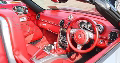 Red leather interior of a Porsche Boxster on display at Simply Porsche 2025, Beaulieu.