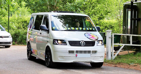 Custom white VW Transporter van entering the showground at Simply VW 2025 in Beaulieu.