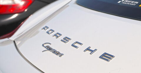 Close-up of Porsche Cayman rear badge at Simply Porsche 2025 event in Beaulieu.